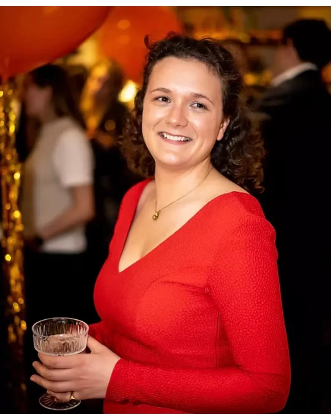 Ophelie de Saint-Romain at an evening event, glass in hand