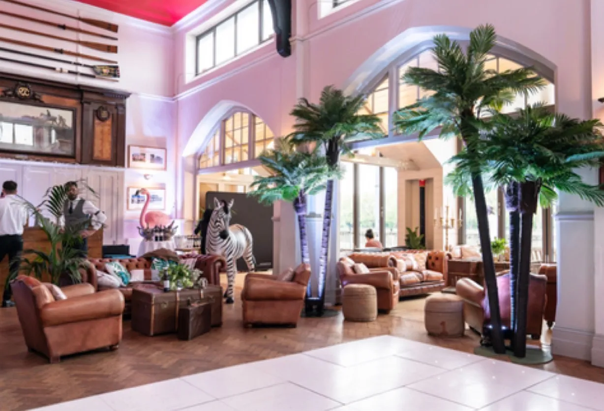 The room dressed for a party, a dance floor laid and leather armchairs grouped under the arched windows